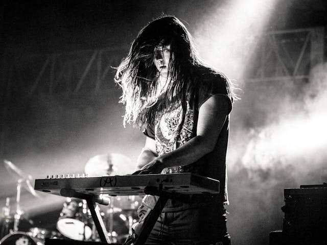 Member of Health performing a keyboard on-stage.