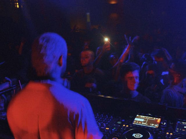 A shot from behind Moktar and their DJ desk, a packed crowd his audience.