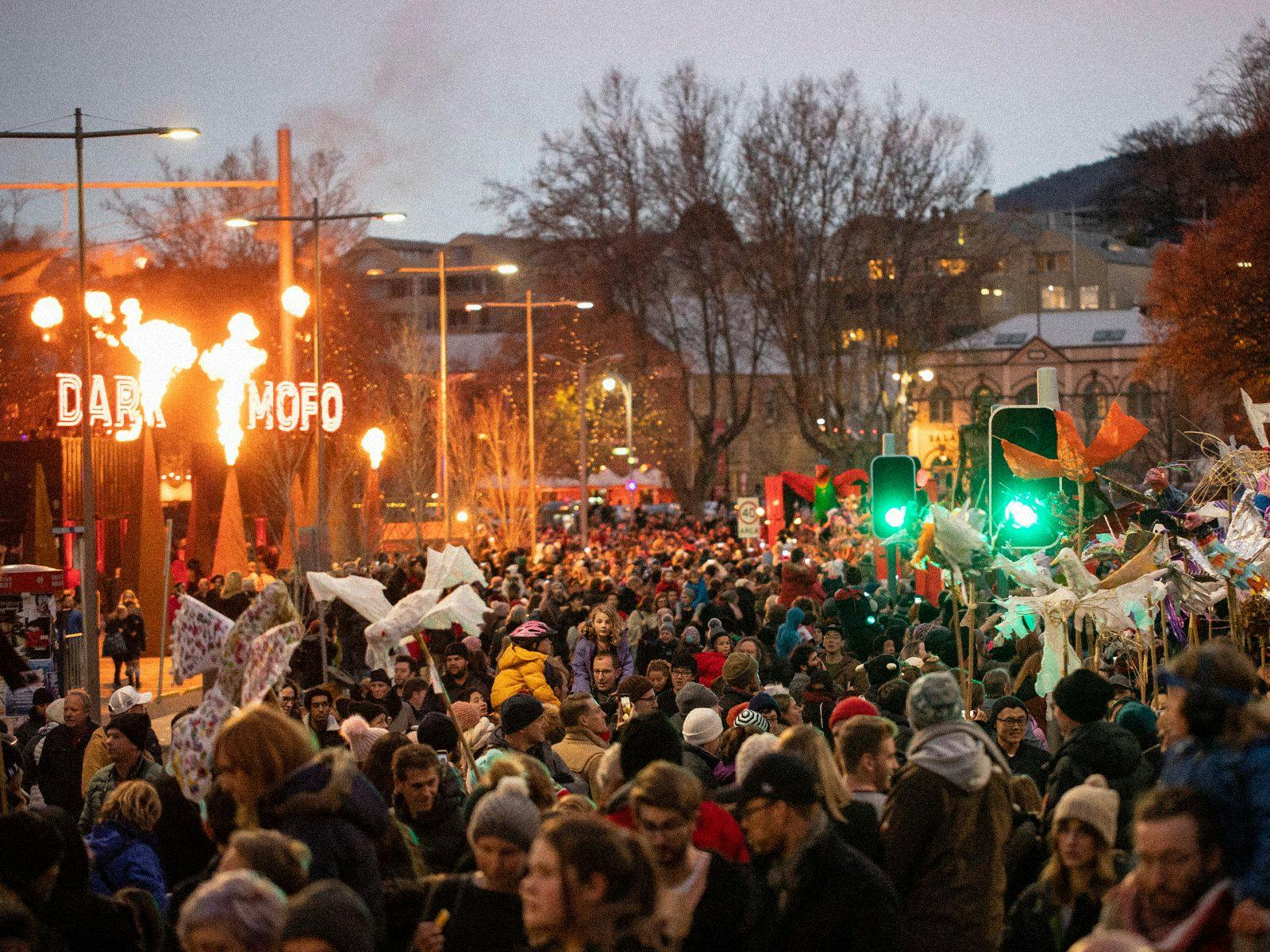 A huge crowd of people walk through the streets of Hobart.