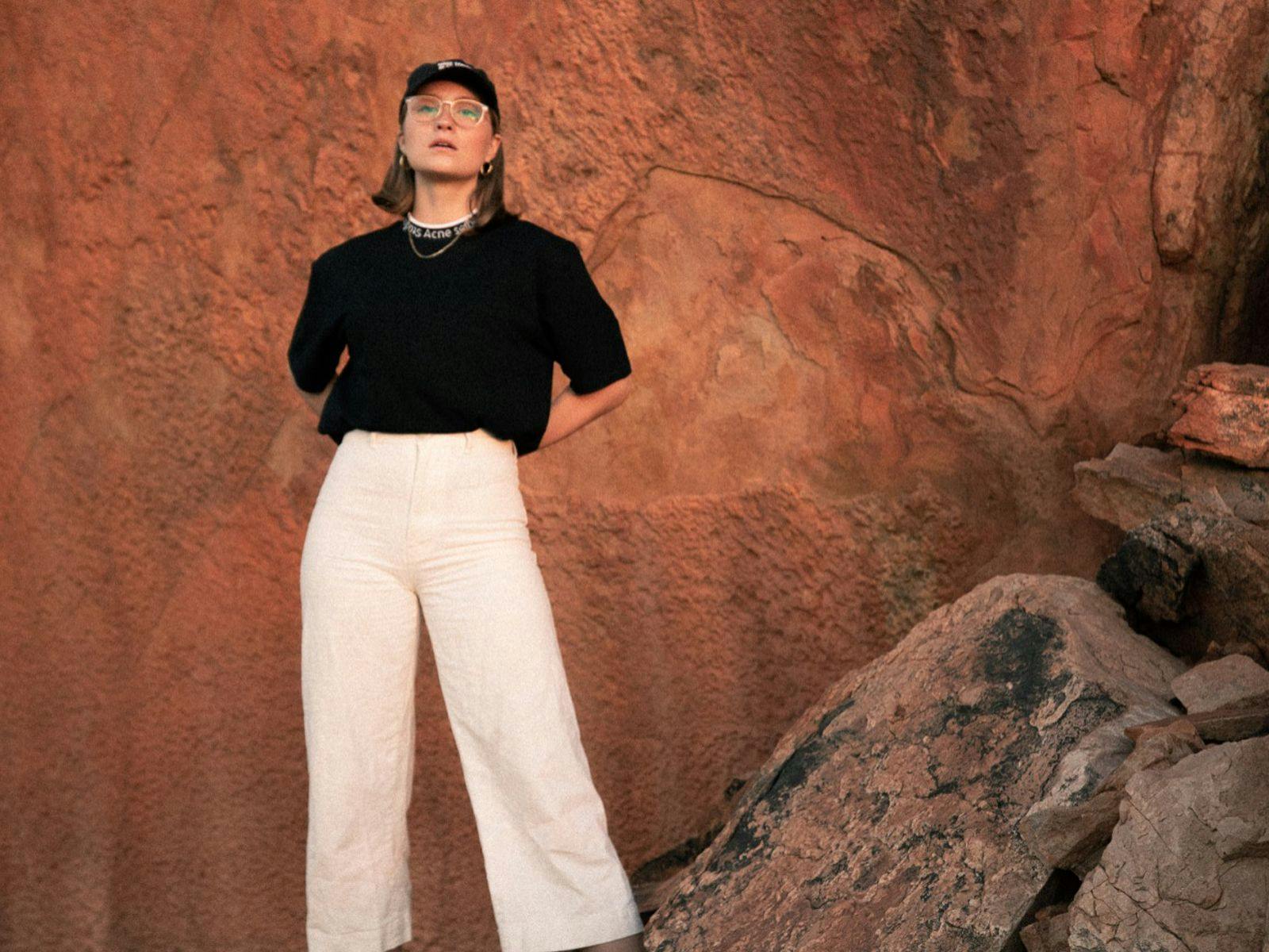 Rona posing against a brown rock background.