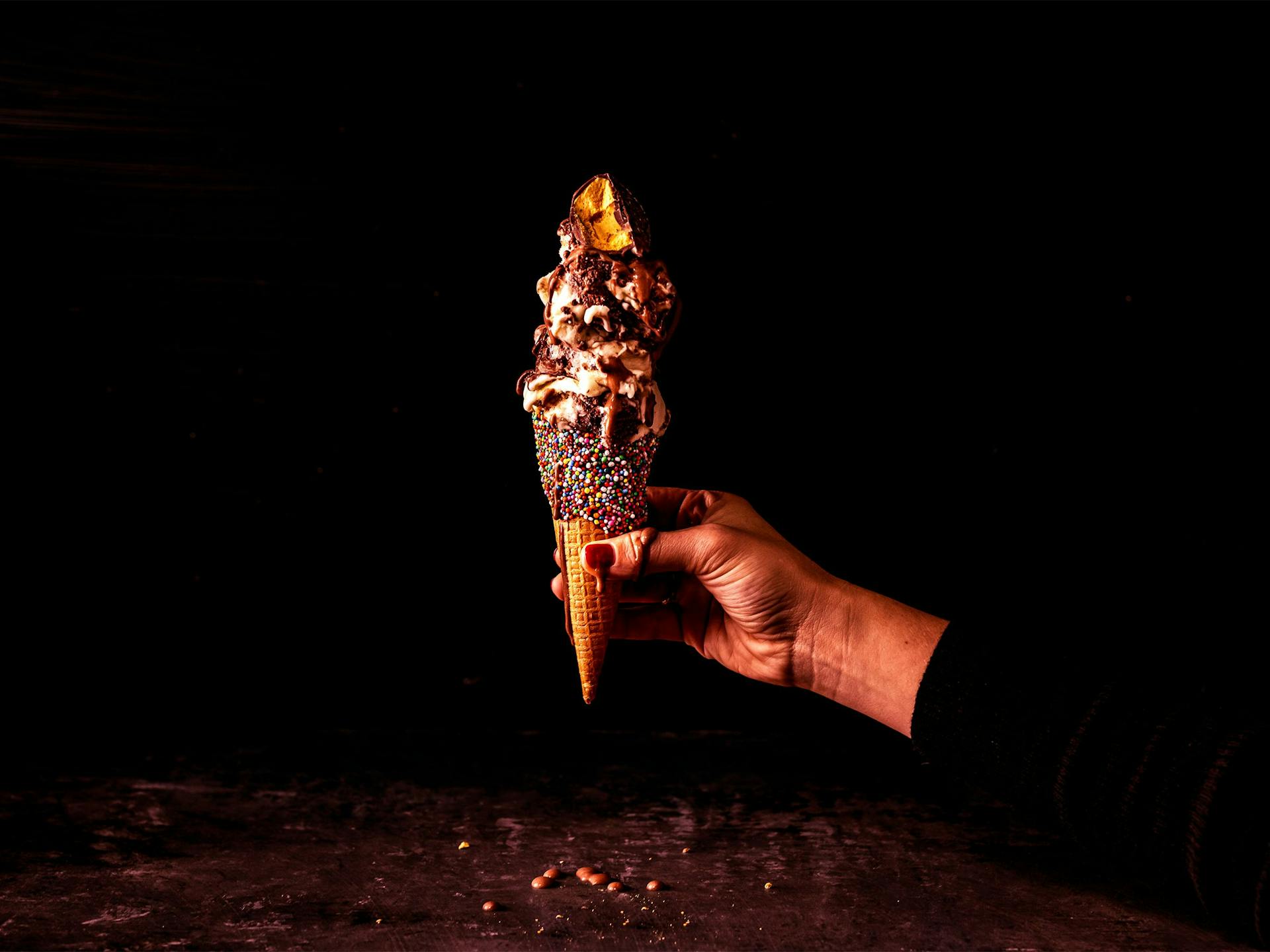 An ice cream cone dripping on a hand