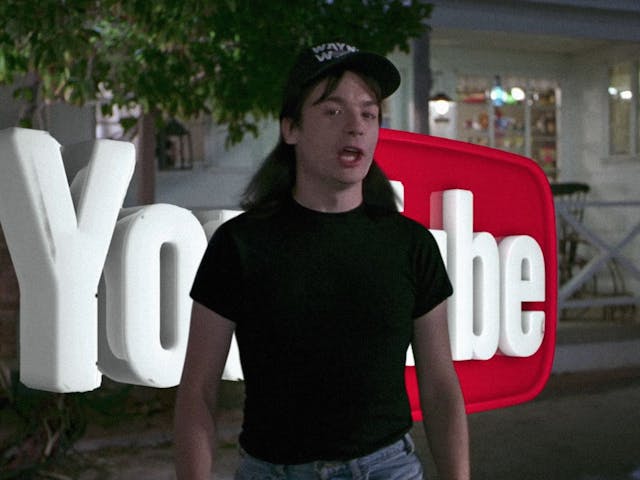 A digitally edited still from the movie Wayne's World, with Wayne walking in front of a large 3D YouTube logo.