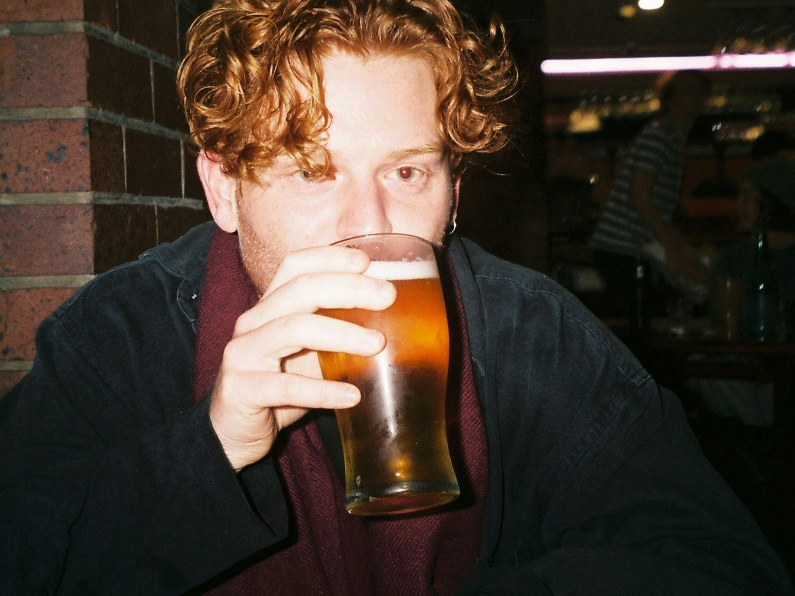 Goth Cum drinking a pint of beer.