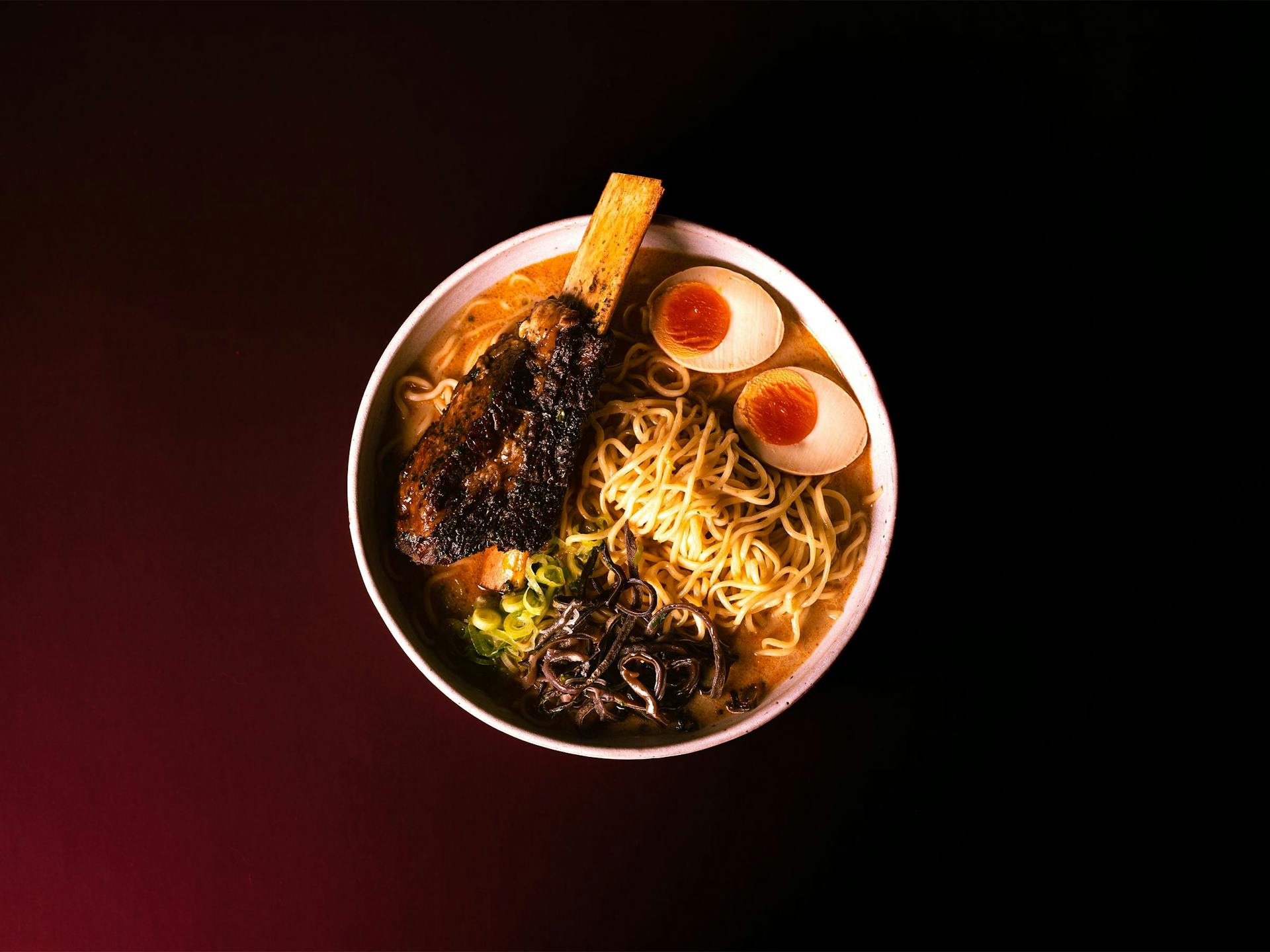 A bowl of Tonkotsu ramen in with soft-boiled egg and beef rib