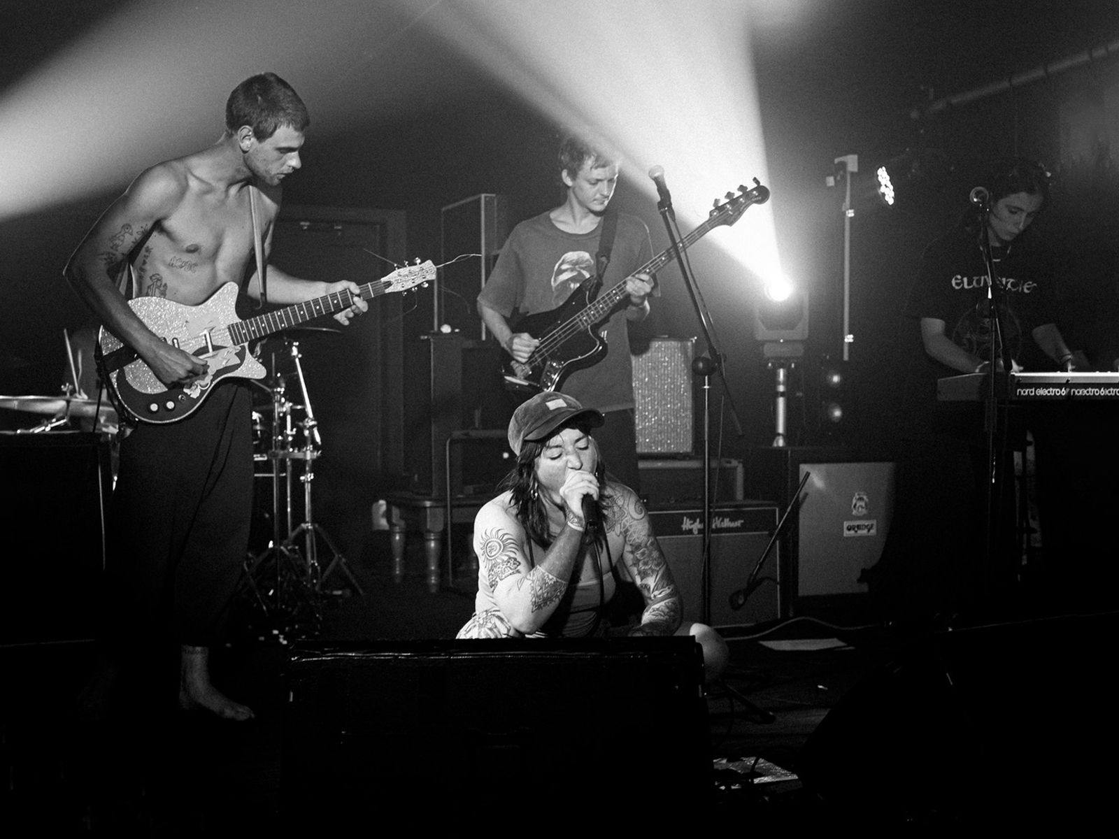 Four members of WÖØLWORTHS­\\FLUSHOT perform on-stage.