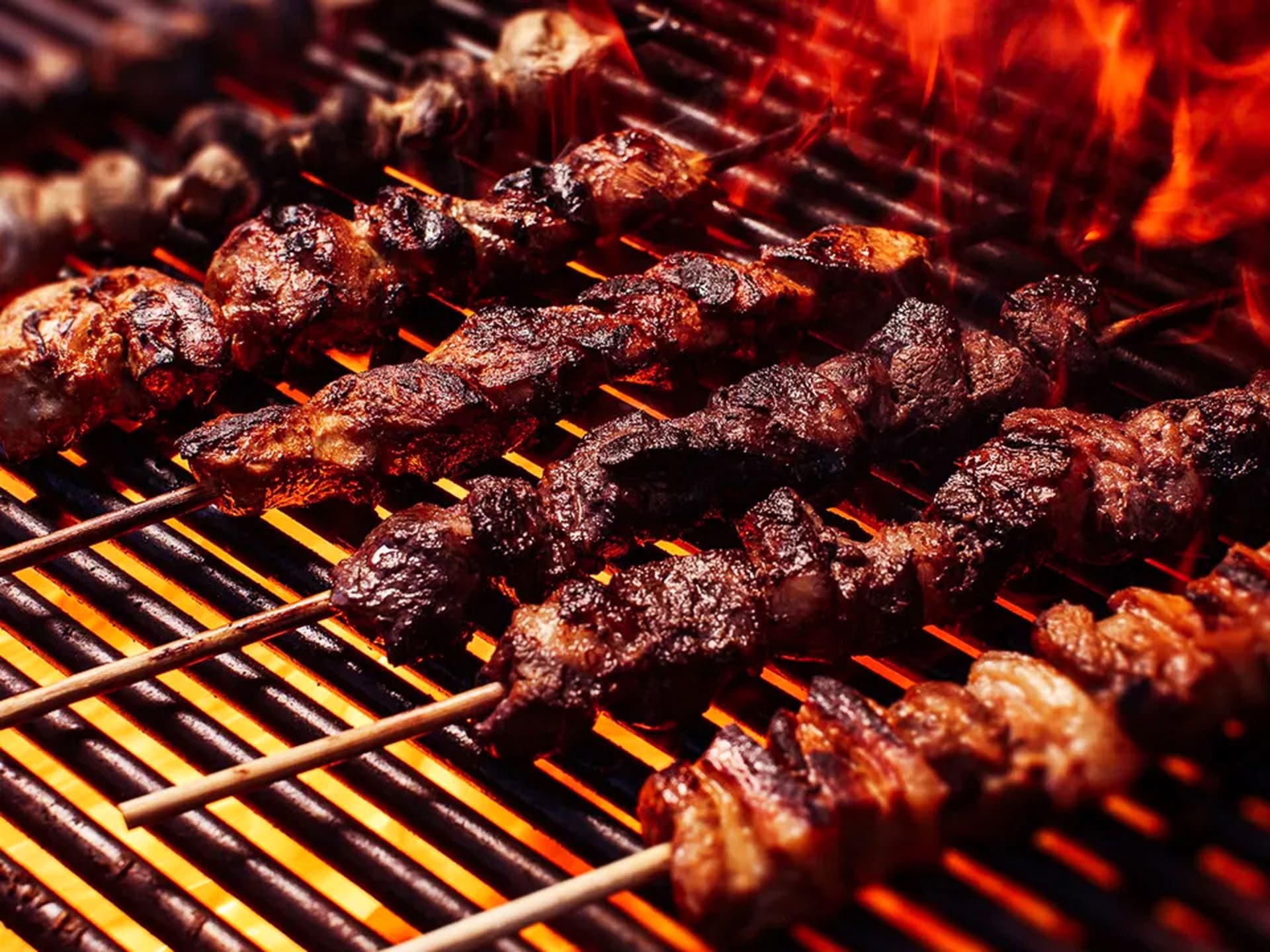 Meat sticks on a grill with fire