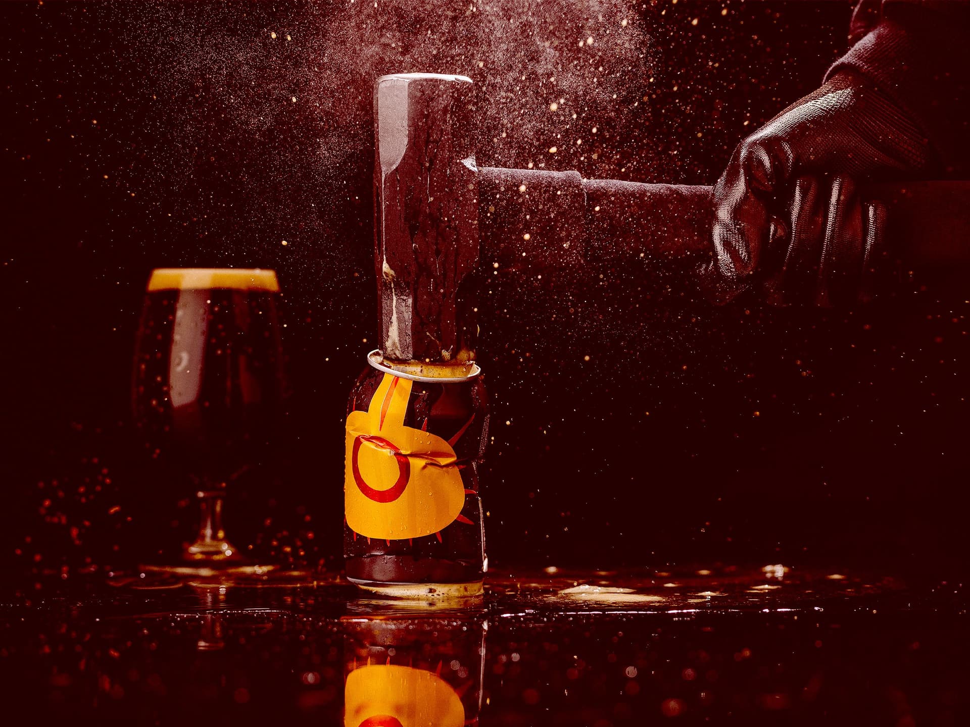 A sledgehammer smashing a can of Moo Brew against a dark background. Foam sprays and oozes everywhere.