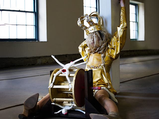 A crowned figure sits on the ground.