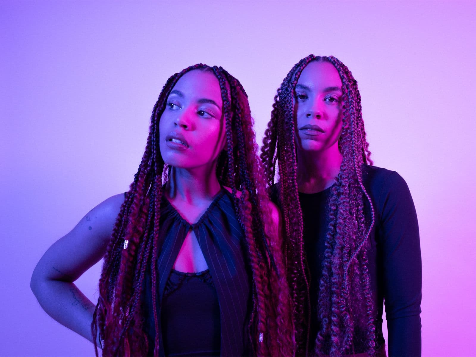 Members of Kinder standing next to each other, lit up by purple and blue lighting.