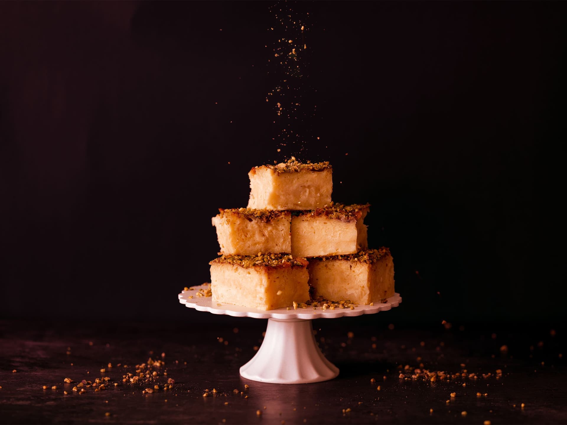 Soufra piled up on an elegant cake stand are sprinkled by chopped pistachios